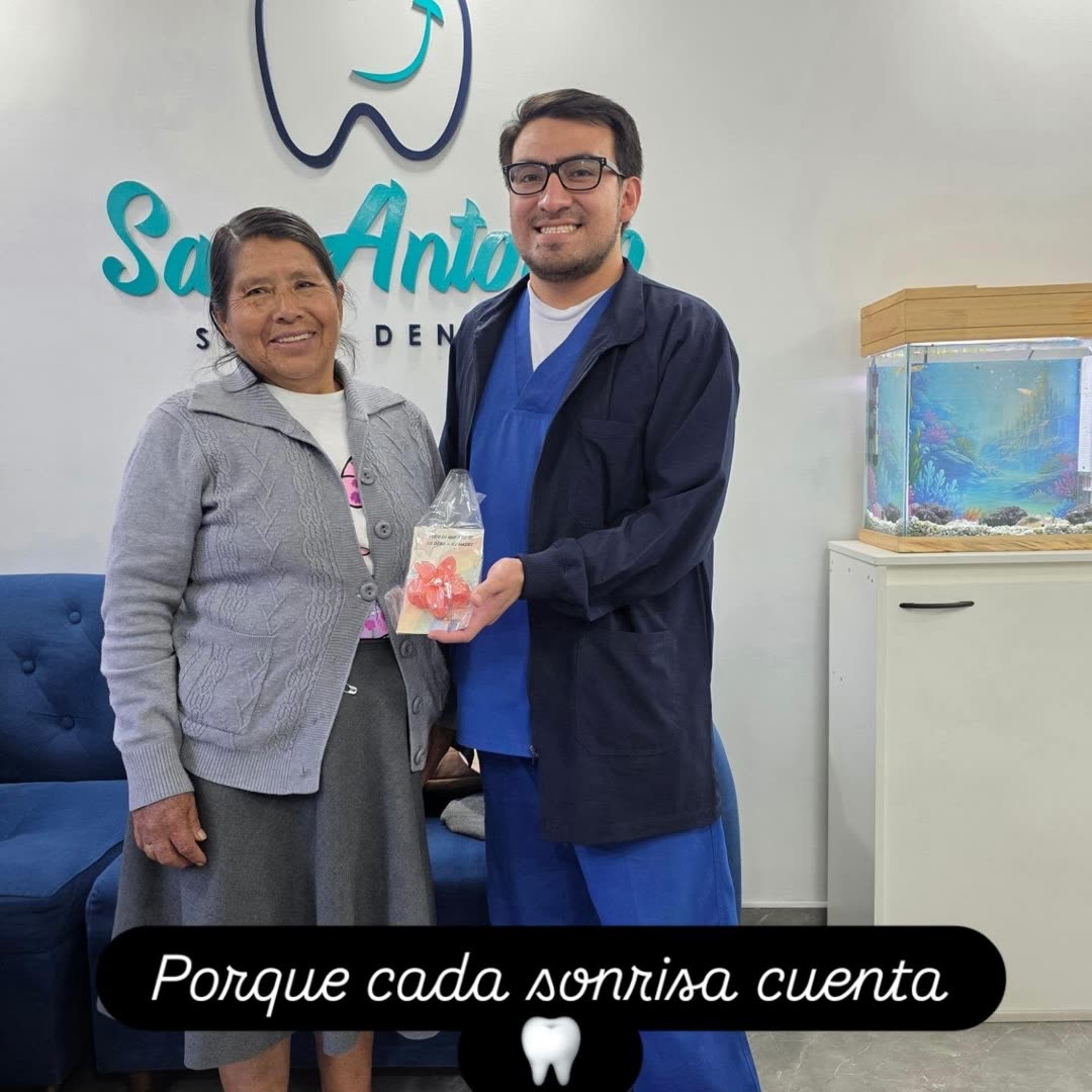 Odontólogo de San Antonio Salud Dental entregando un detalle a una paciente en la clínica