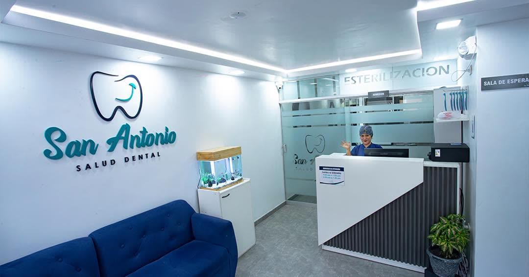 Recepción de San Antonio Salud Dental: ambiente moderno y luminoso con el logo en la pared, sala de espera y zona de esterilización